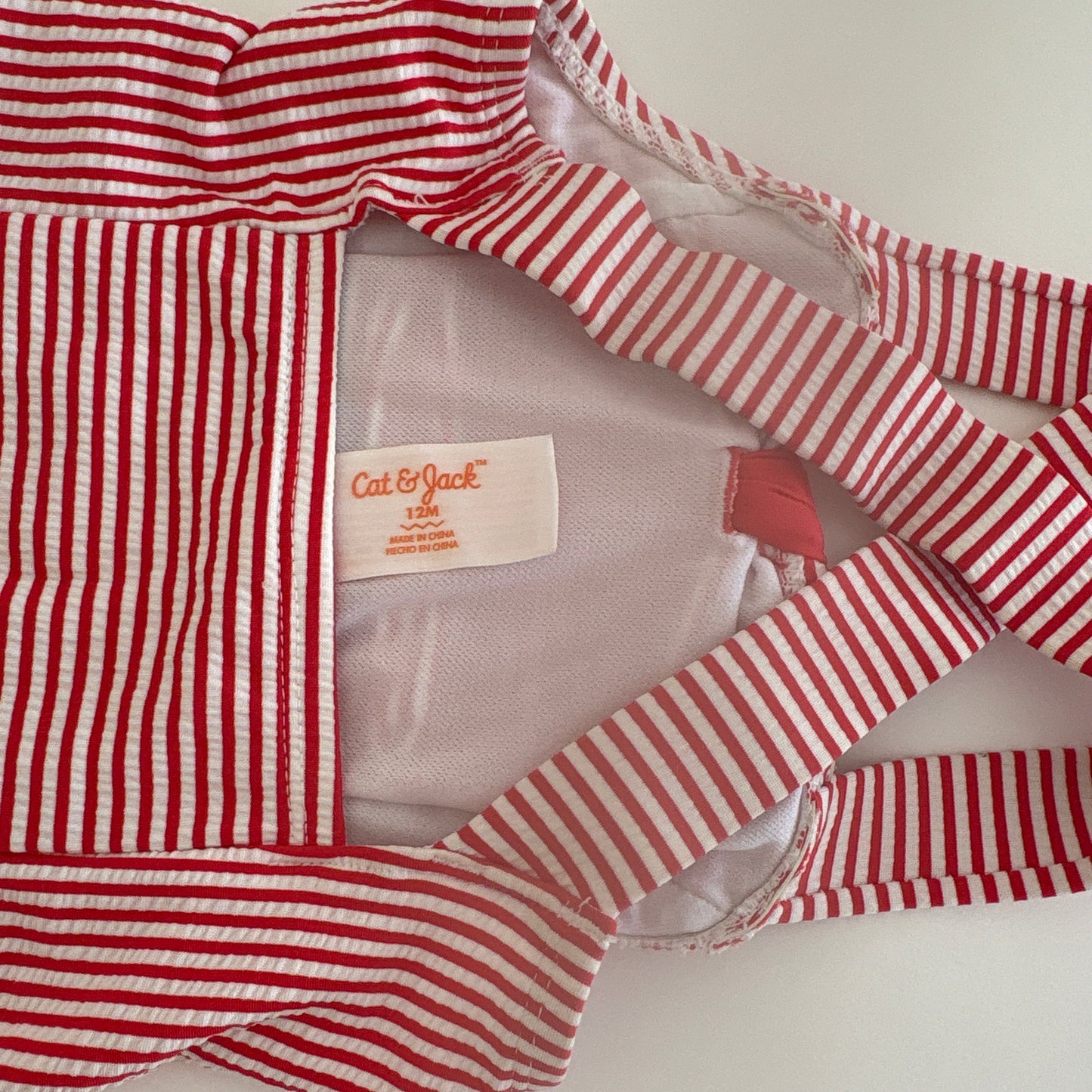 Red and white striped garment with a visible brand label on a light background