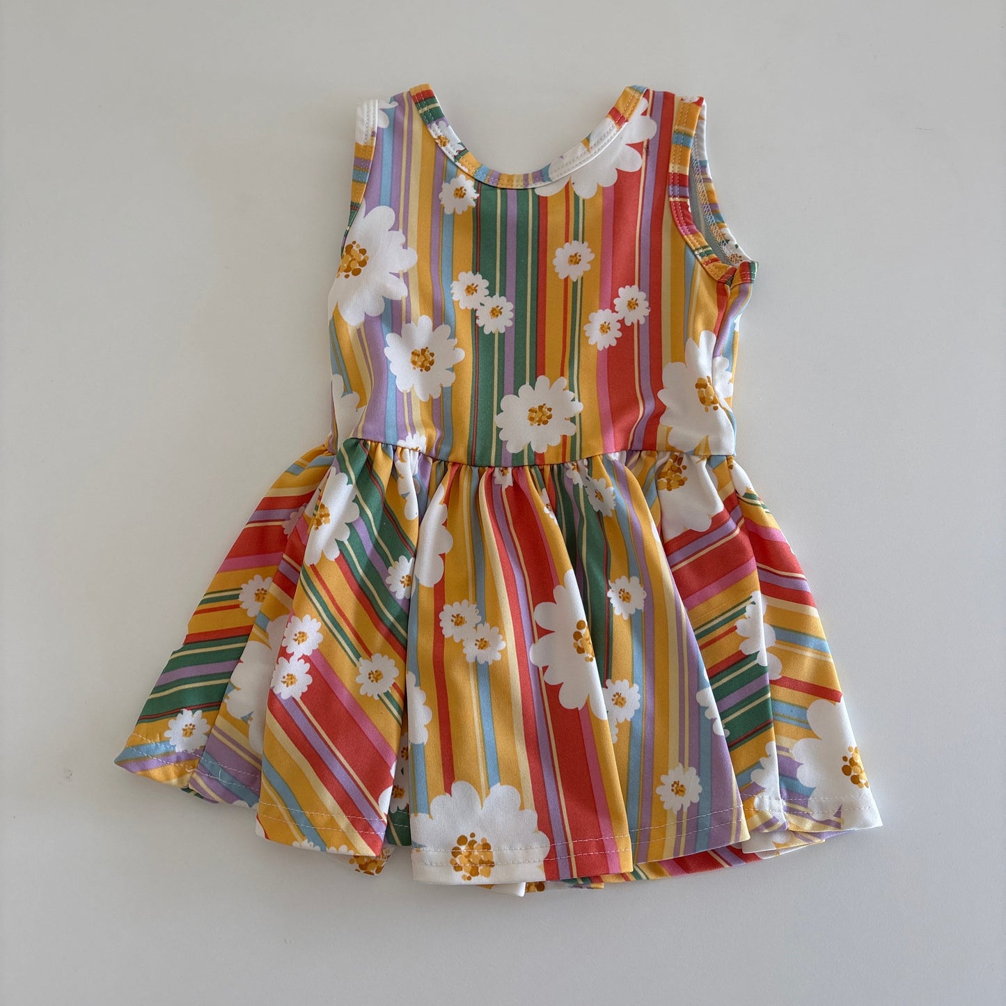 Colorful striped dress with floral patterns on a light gray background
