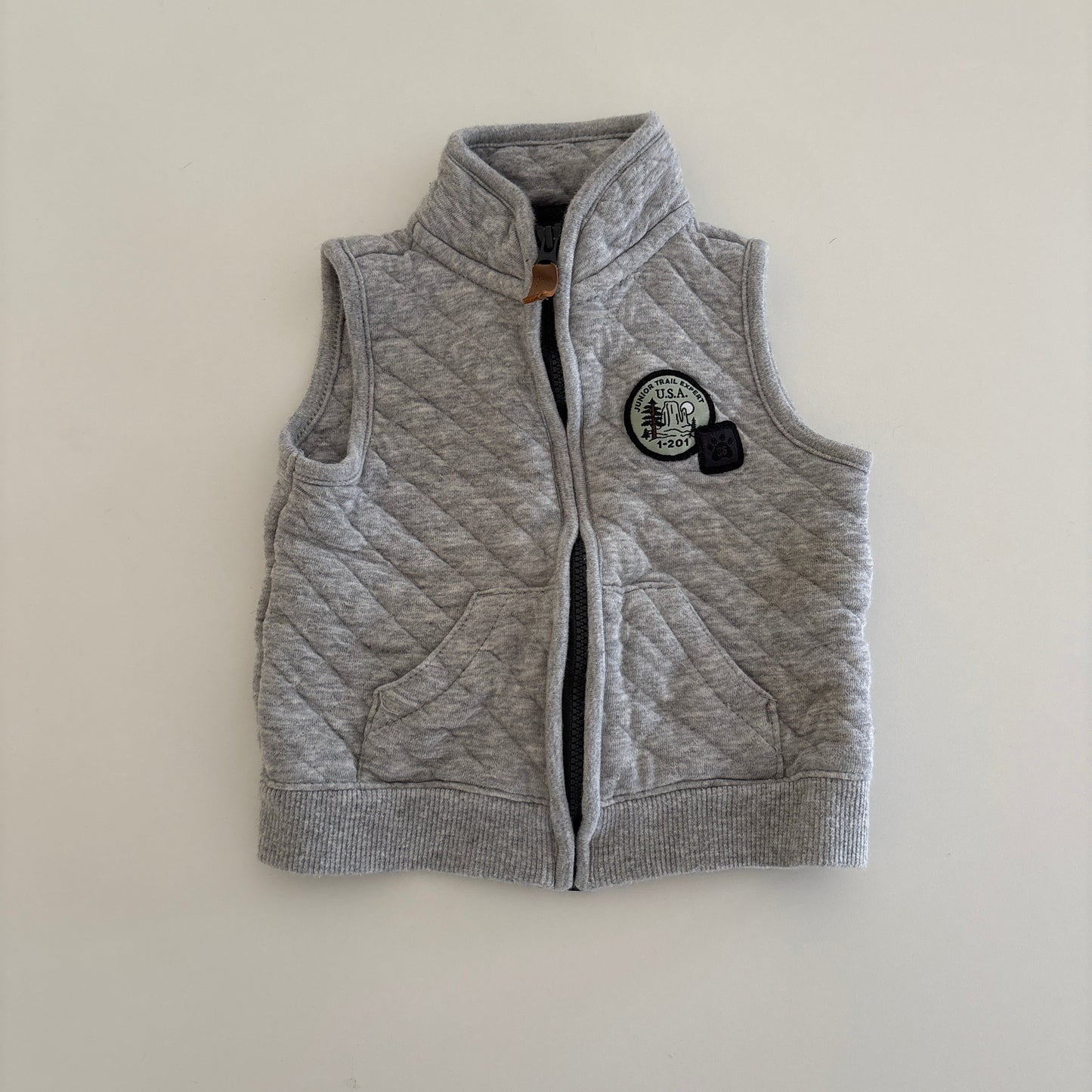 Gray zip up vest on light background