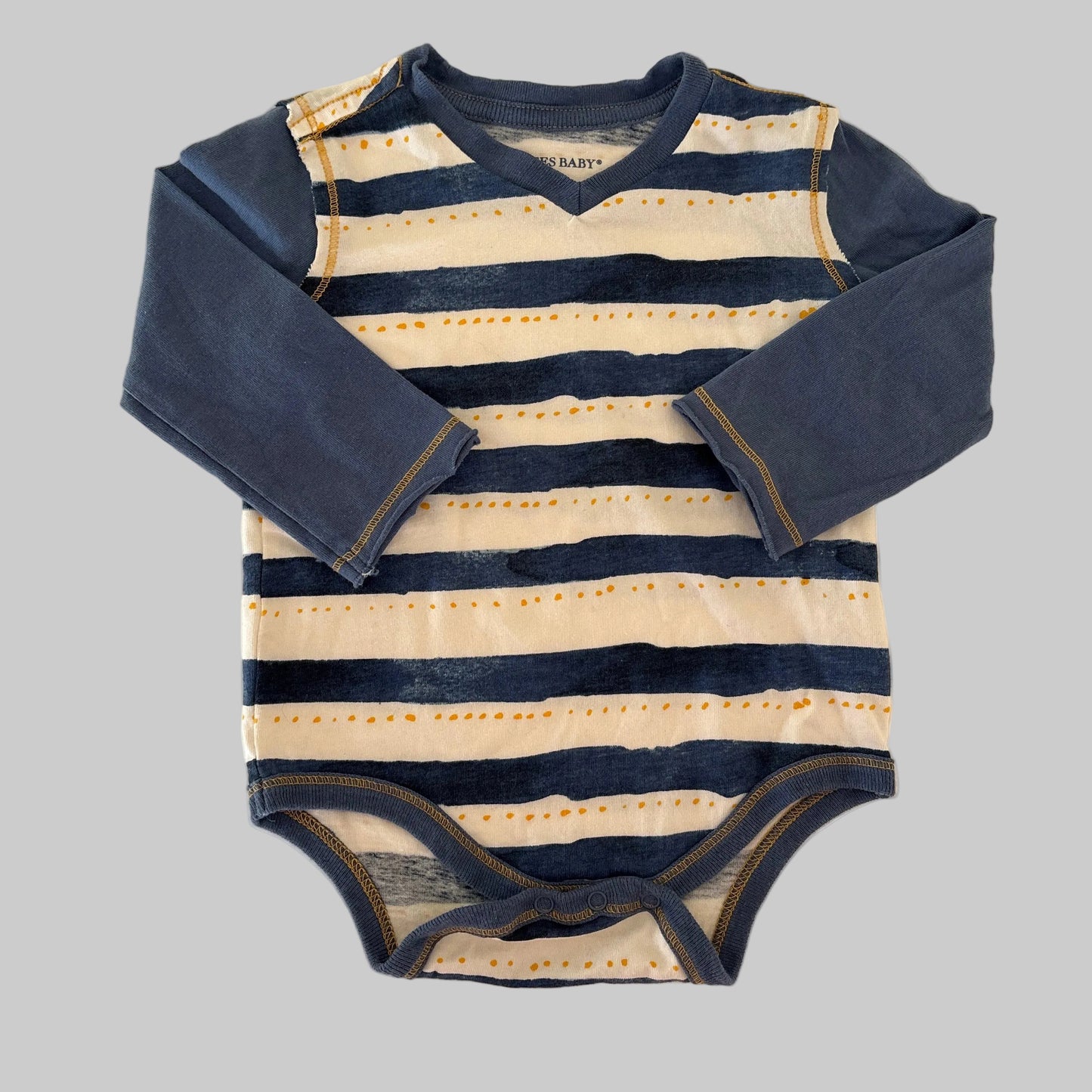 Striped outfit with navy and beige colors on a beige background