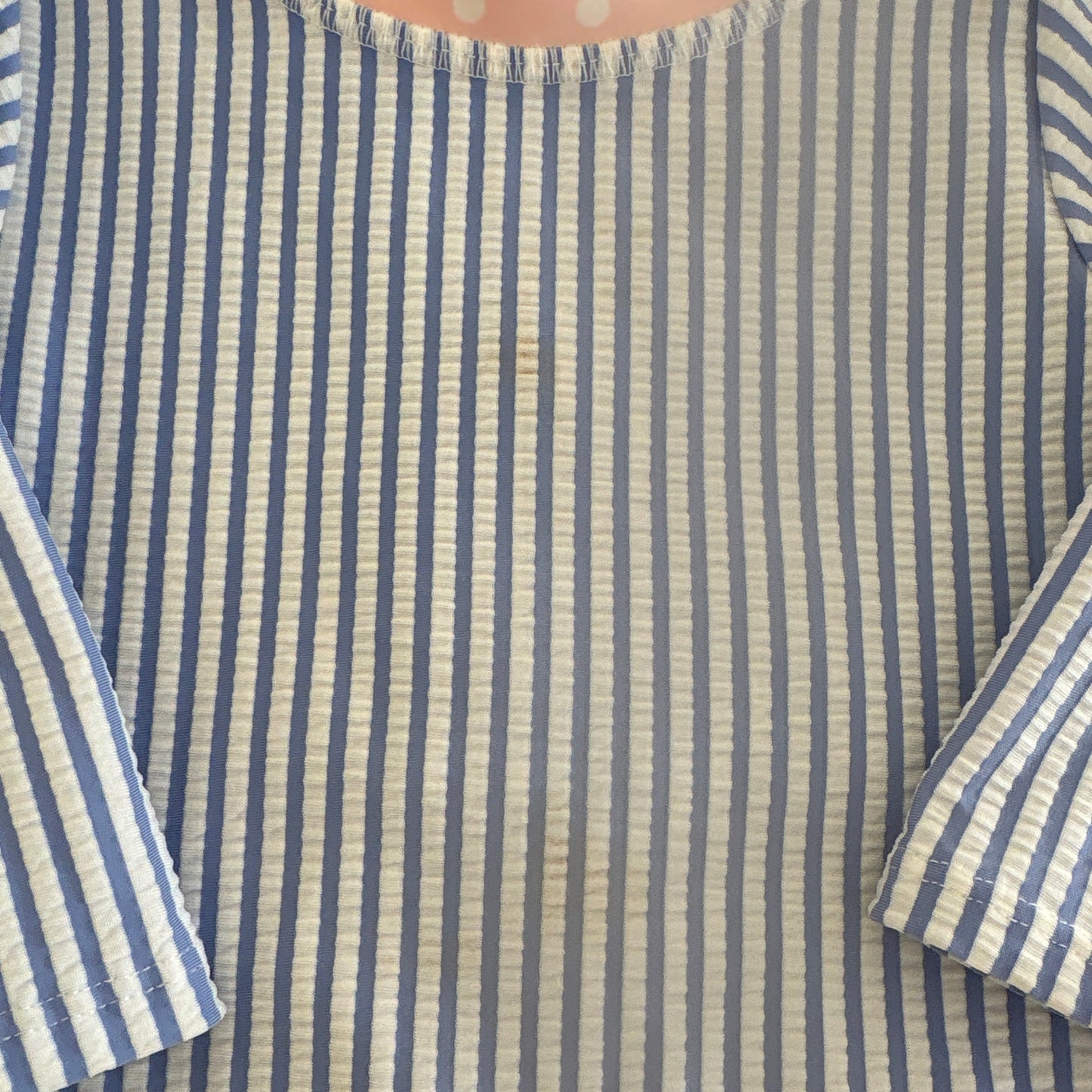 Shows small discolorations on front of swimsuit