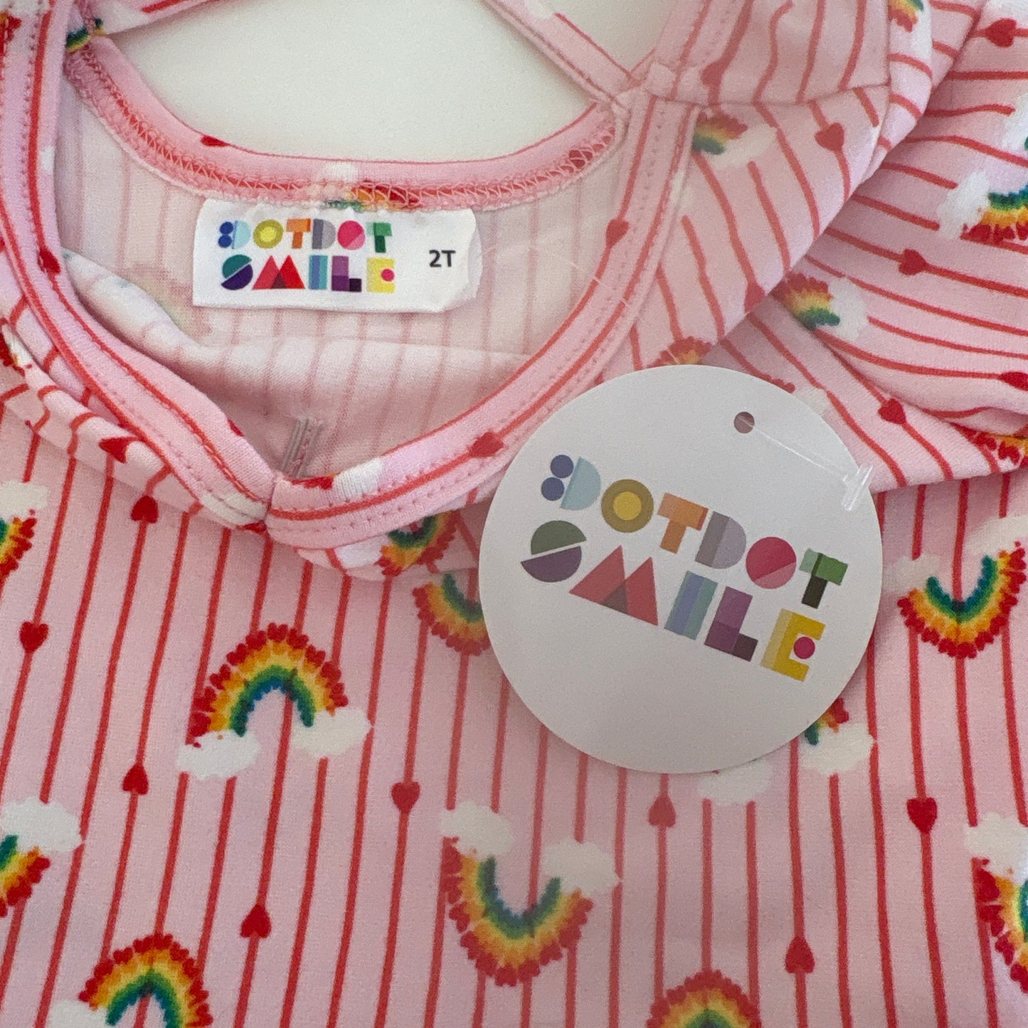 Baby outfit with rainbow patterns and 'Dotdot smile' label on a white background
