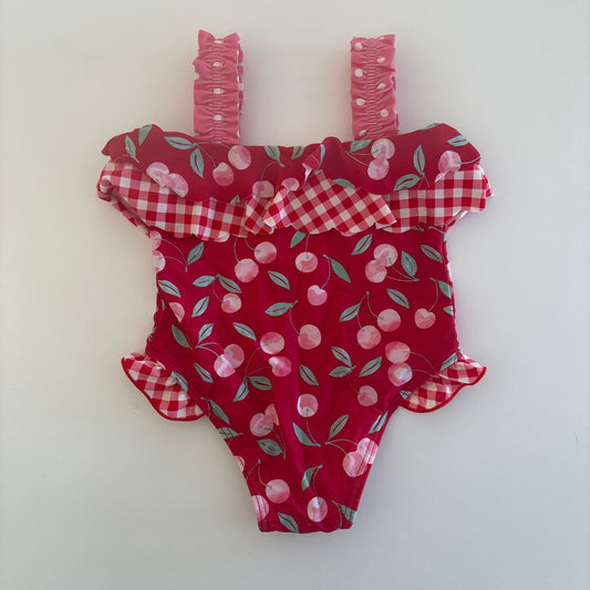 Red fabric dress with cherry pattern on a white background