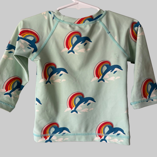 dolphin and rainbow long sleeve swim shirt on a white hanger