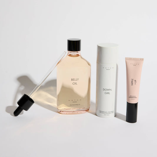 Belly oil, skincare cream, and lotion on a white background