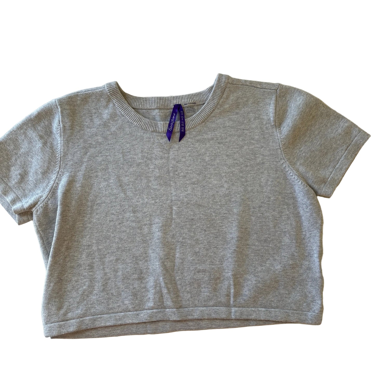 Gray sleeveless top with a small logo on a beige surface