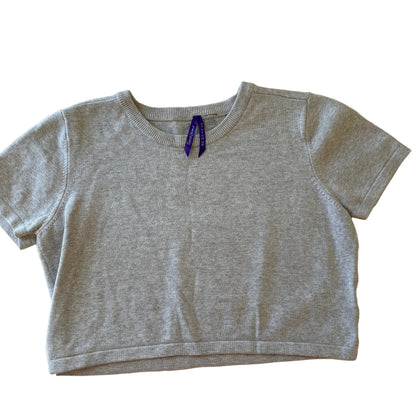 Gray sleeveless top with a small logo on a beige surface