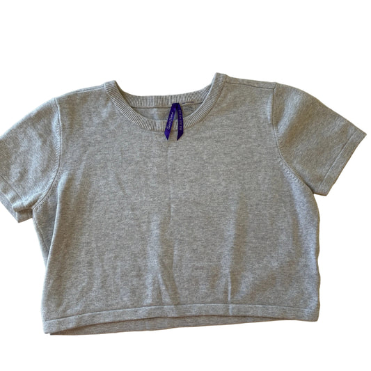 Gray sleeveless top with a small logo on a beige surface