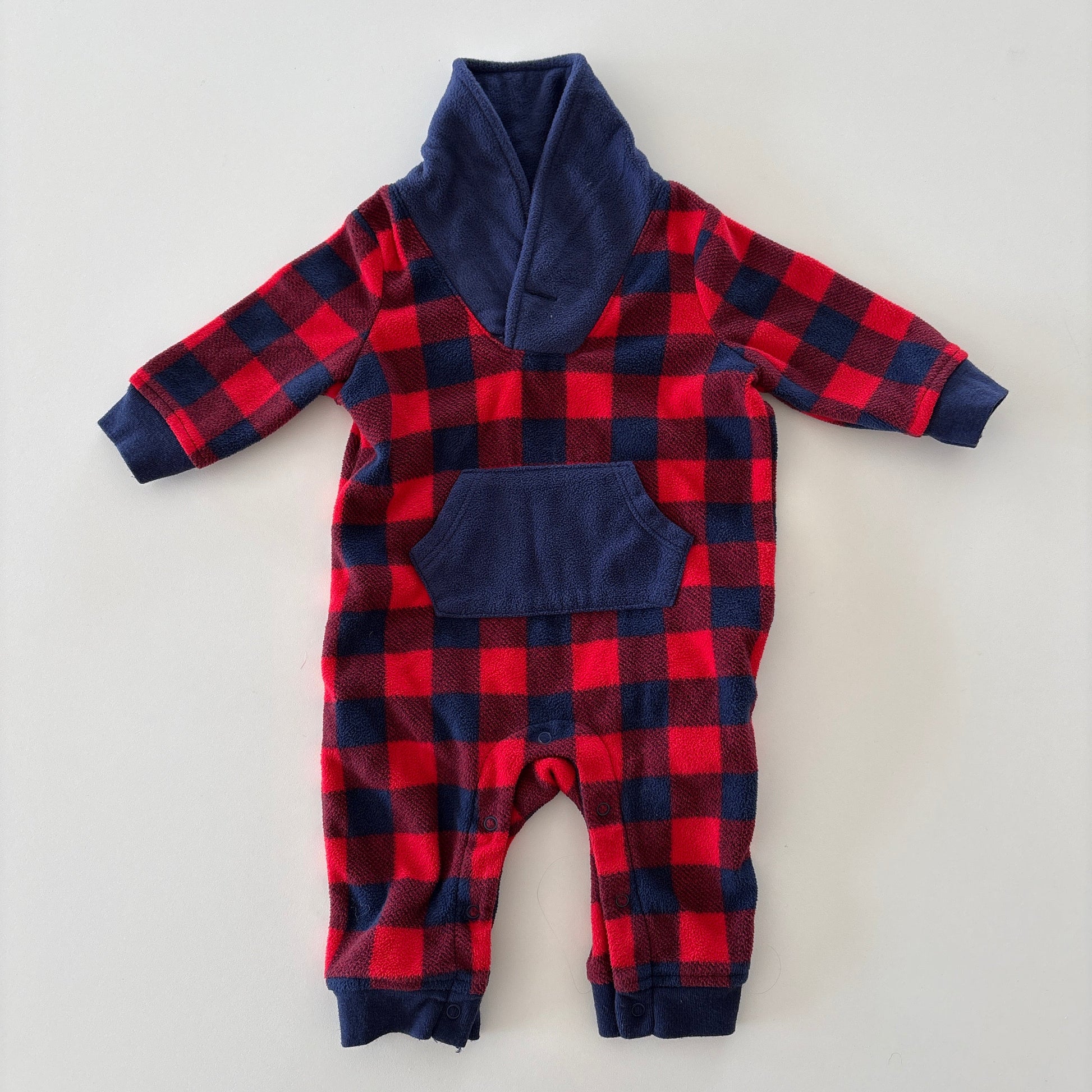 A baby's long-sleeve footless one-piece jumpsuit featuring a red and navy buffalo plaid pattern with solid navy blue trim on the collar, cuffs, and pockets, laid flat on a light gray background.