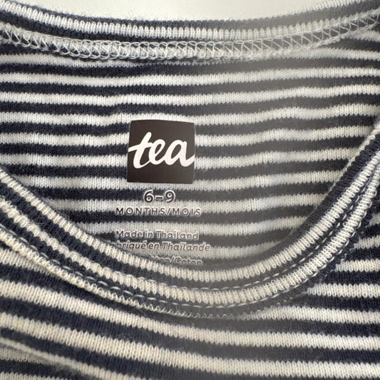 Close-up of a striped garment with a 'tea' brand label.