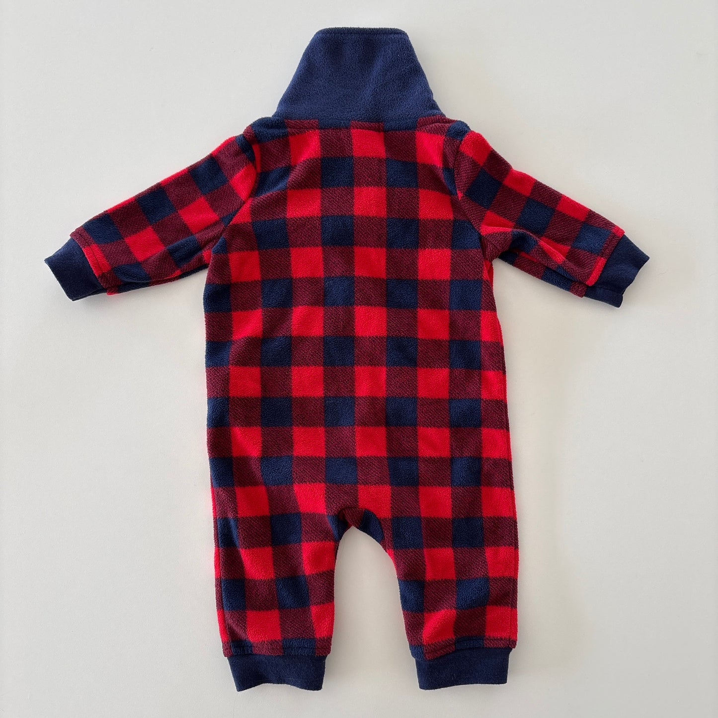 A baby's long-sleeve footless one-piece jumpsuit shown from the back, featuring a red and navy buffalo plaid pattern with a solid navy blue collar and cuffs.
