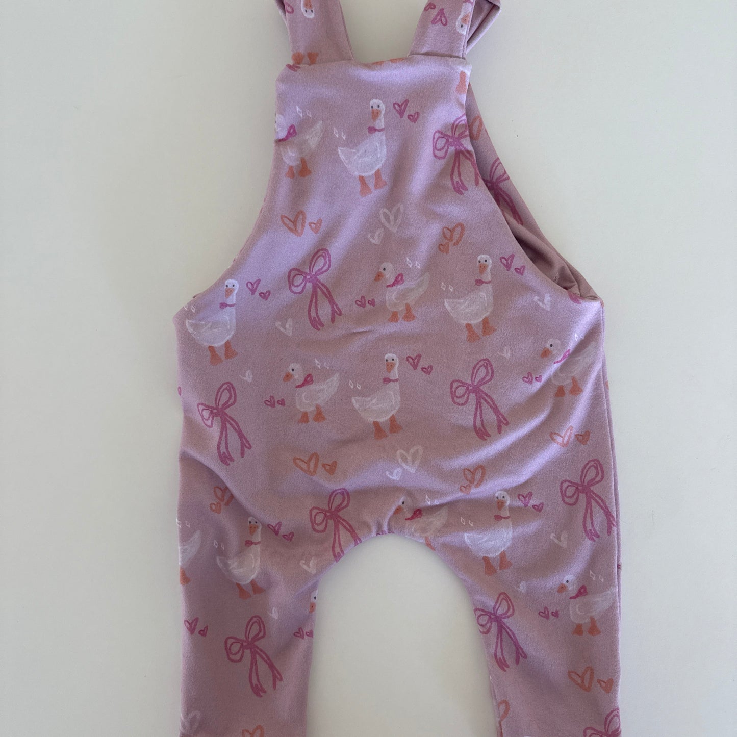 Purple children's romper with pattern on a white background
