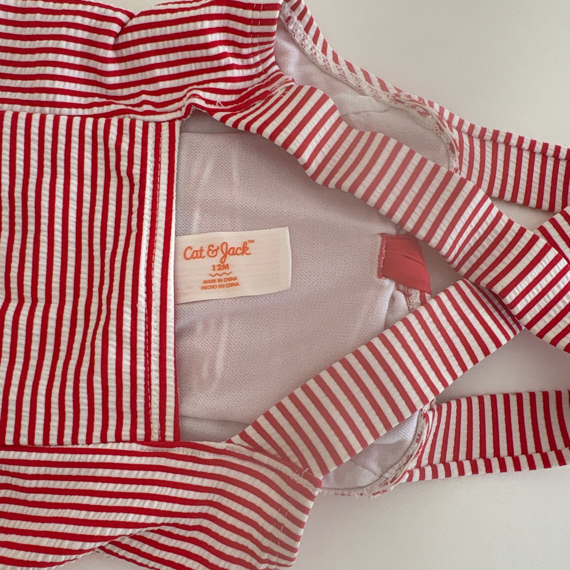 Red and white striped garment with a visible brand label on a light background