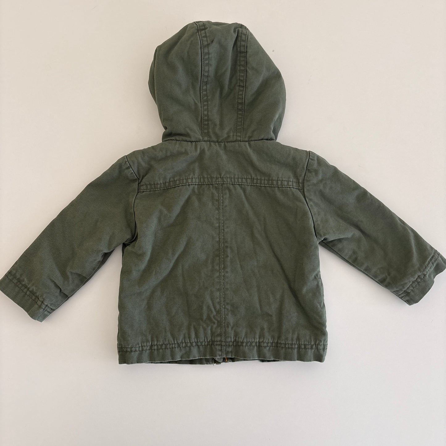 Green children's jacket on a white surface