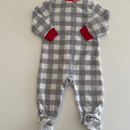 Plaid baby outfit with red accents on a white surface