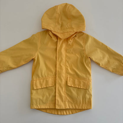 Yellow raincoat on a white surface