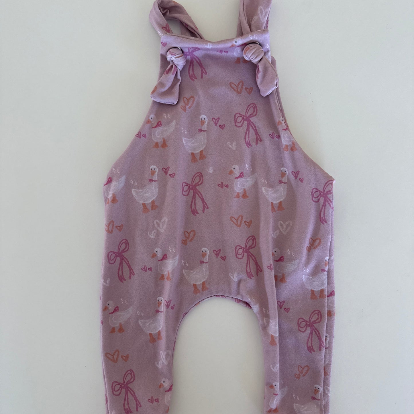 Purple baby romper with floral pattern on a white background