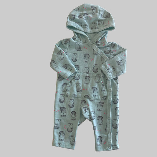 Aqua baby outfit with owl pattern on a beige background