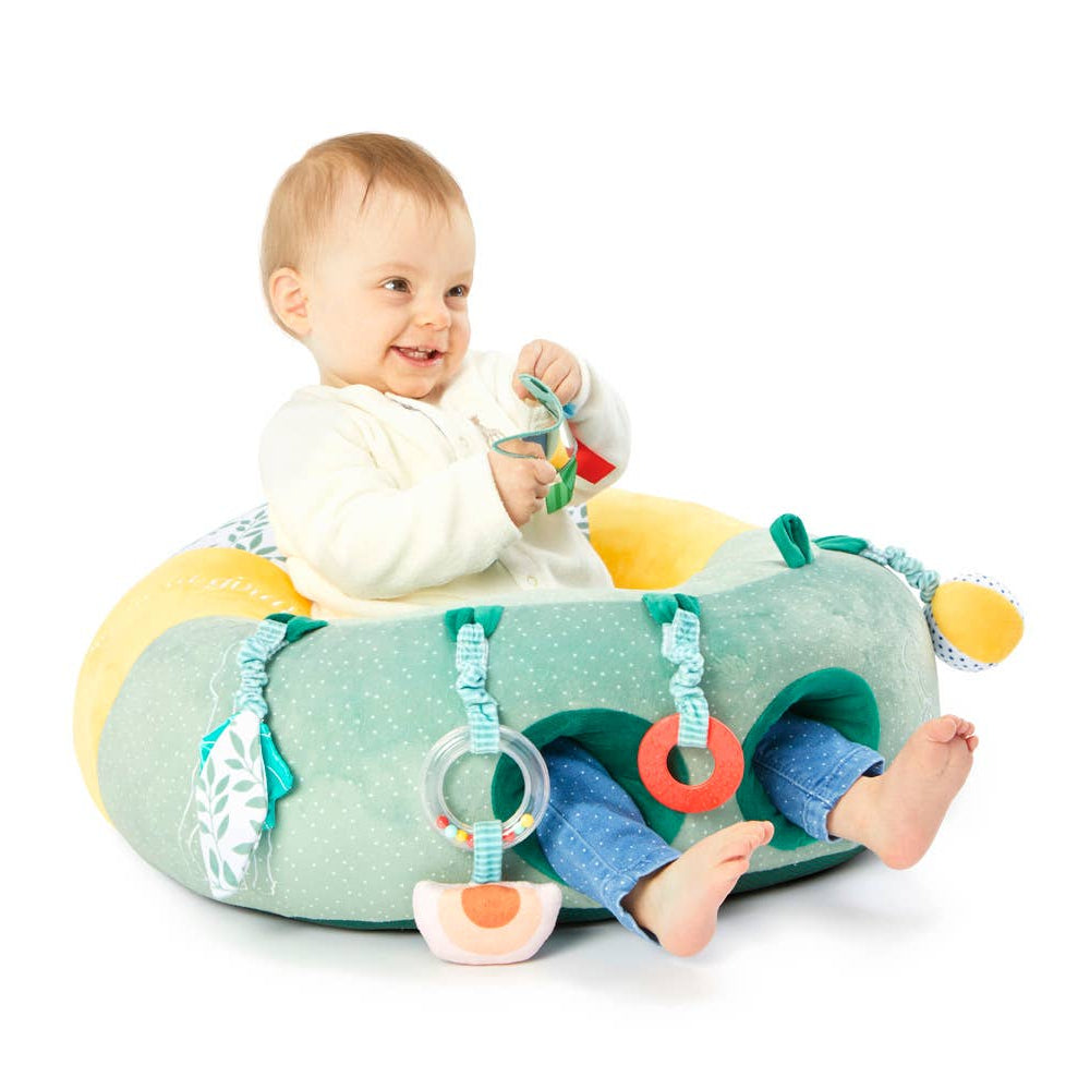 Baby playing with a colorful activity toy on a white background