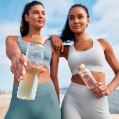 Two women holding water bottles with a clear background