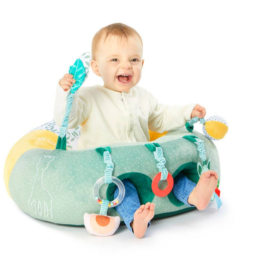 Baby playing with a colorful activity center on a white background
