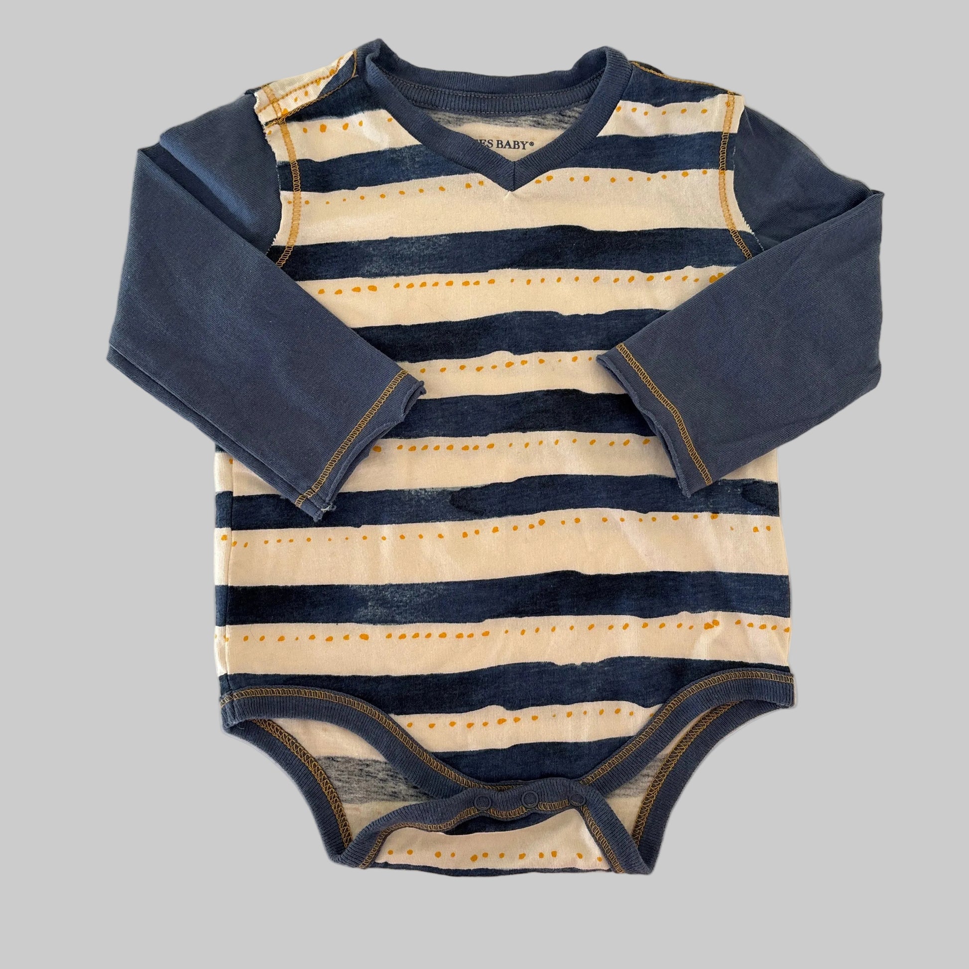 Striped outfit with navy and beige colors on a beige background