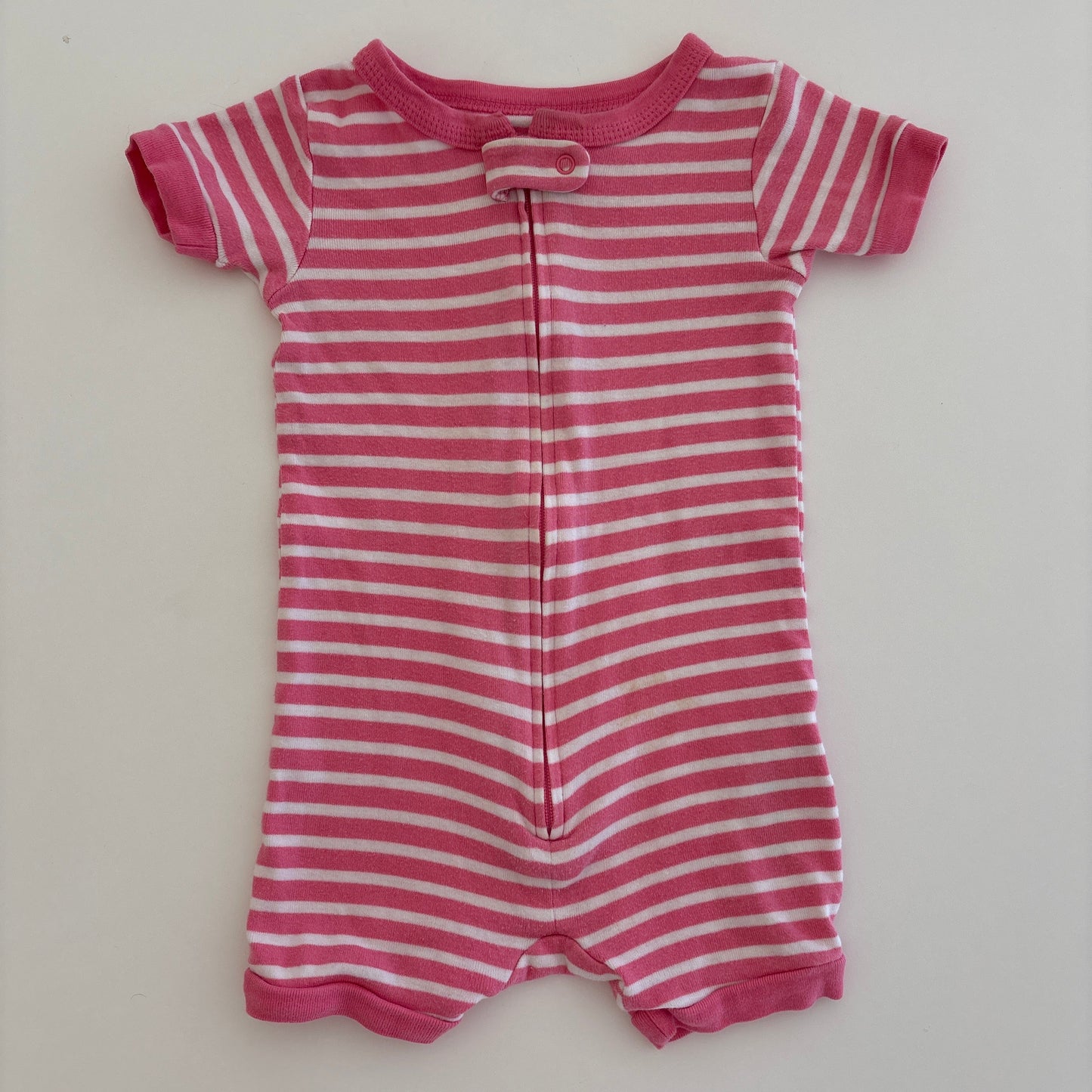 Pink and white striped baby romper on a light gray background