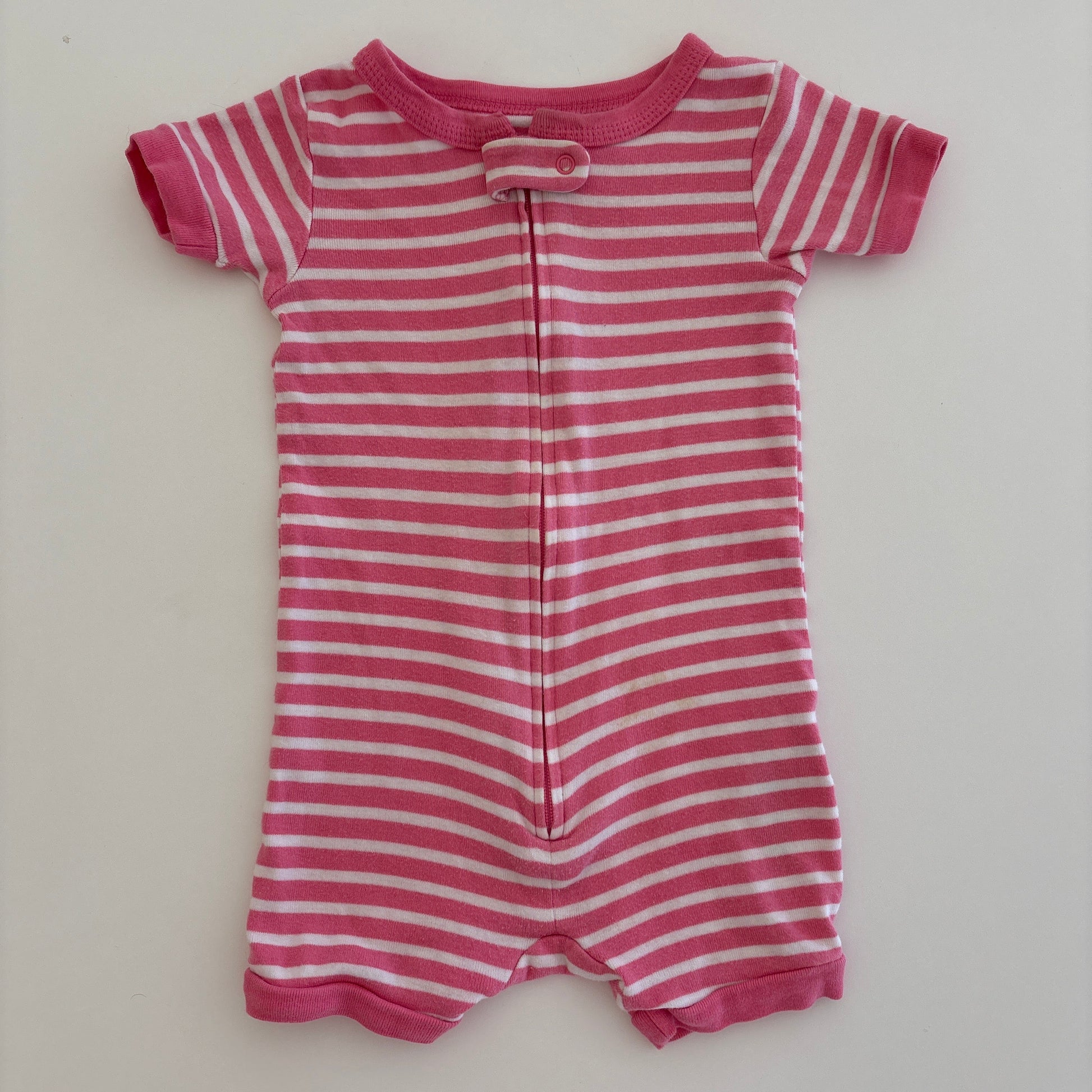 Pink and white striped baby romper on a light gray background