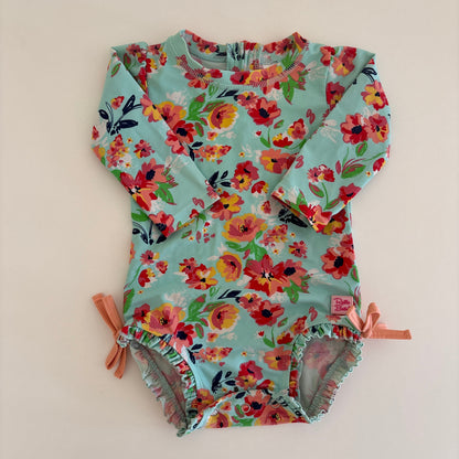 Floral-patterned baby swimsuit on a light beige background