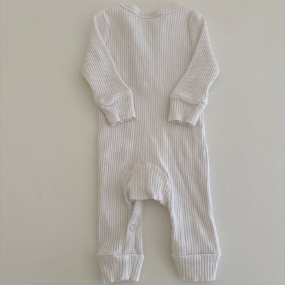White ribbed baby onesie on a light gray background