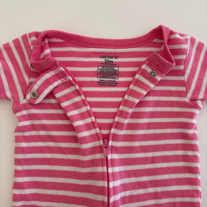 Pink and white striped baby onesie on a light beige background