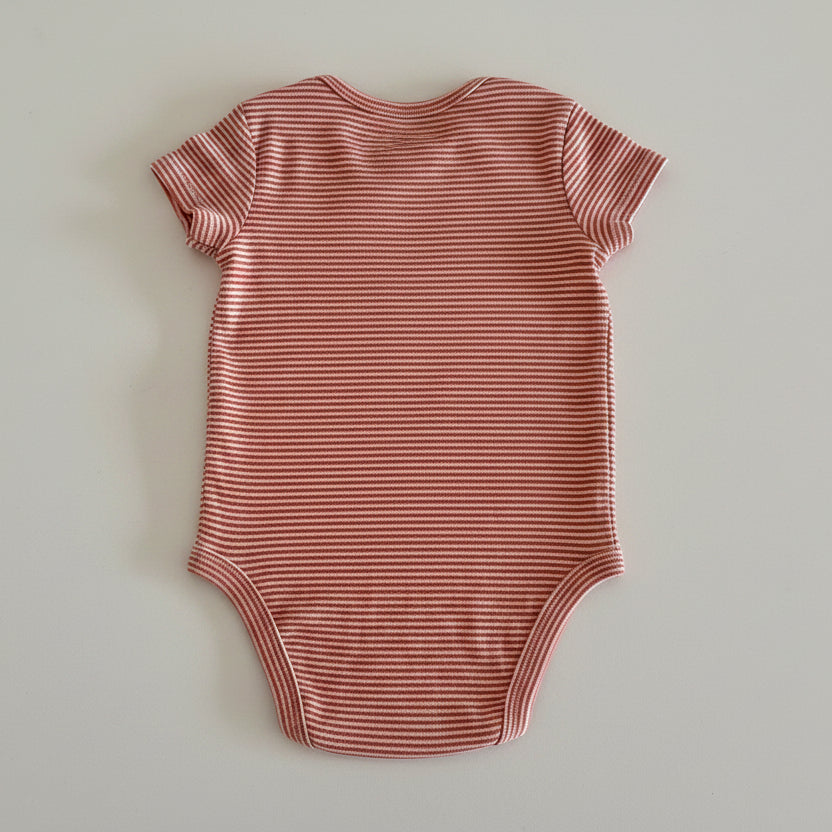 orange and white striped baby bodysuit on light background