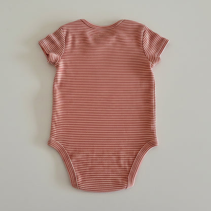orange and white striped baby bodysuit on light background