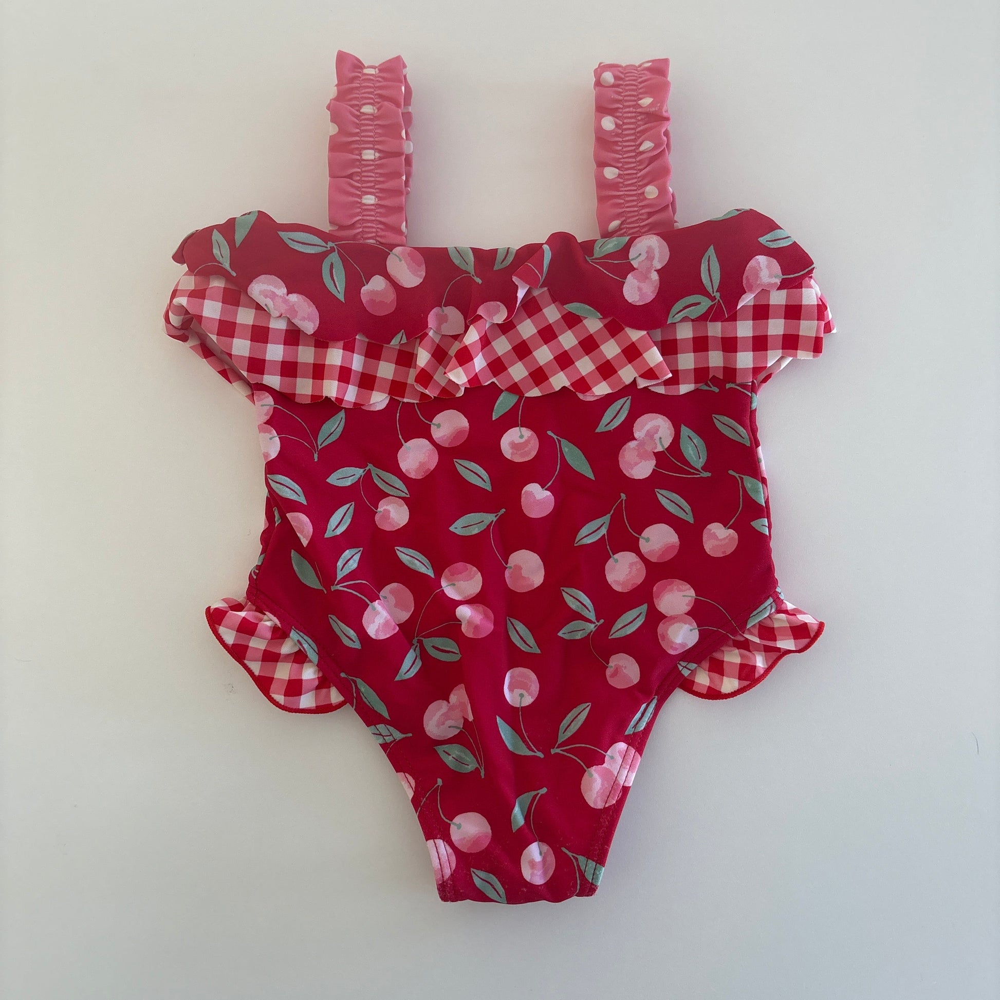 Red fabric dress with cherry pattern on a white background