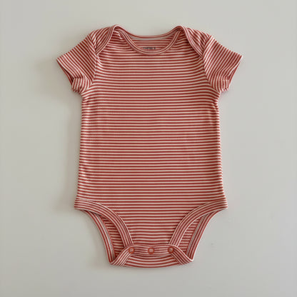orange and white striped baby onesie on a light gray background