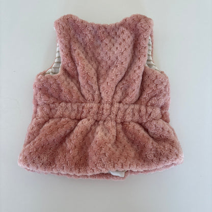 A pink fuzzy knit pet vest with a textured knit body, gathered waist, and ribbed trim, shown flat on a light off-white background.