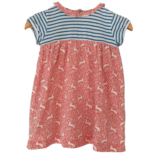 A short-sleeved spring dress for a toddler, with a red bodice featuring a bunny pattern and a blue striped top, on a hanger against a plain background.