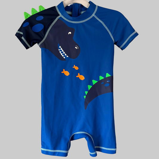 A blue one-piece toddler swimsuit with short sleeves, featuring dinosaur character designs.
