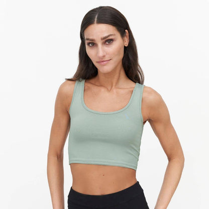Woman wearing a green nursing bra on a white background