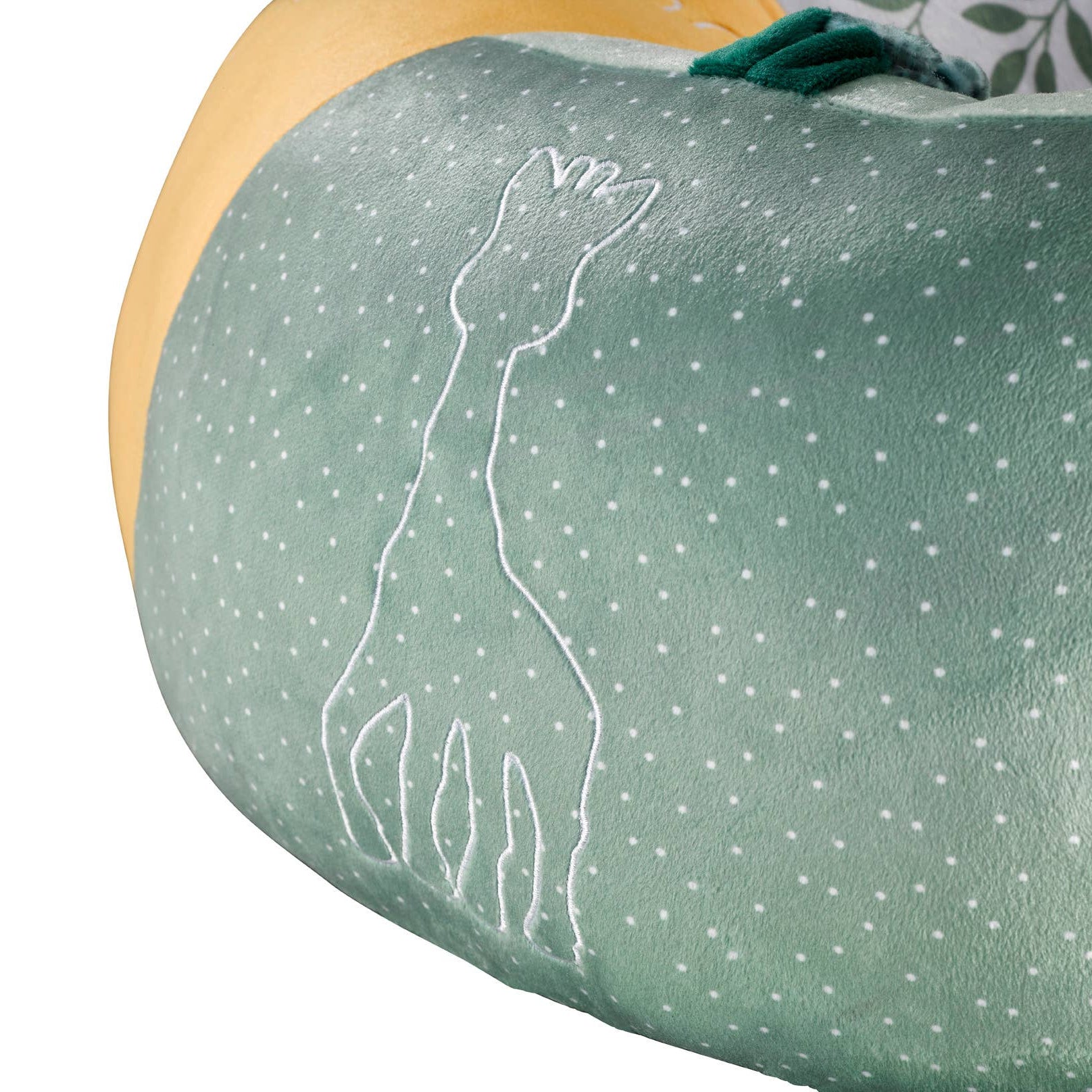 Green fabric with white dot pattern and embroidered giraffe design on a white background