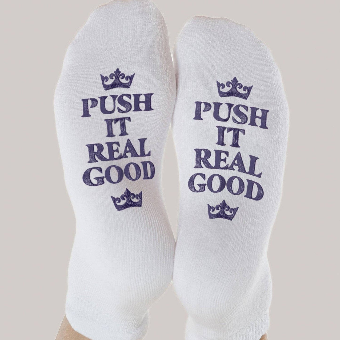 White socks with 'Push It Real Good' text and crowns on a neutral background